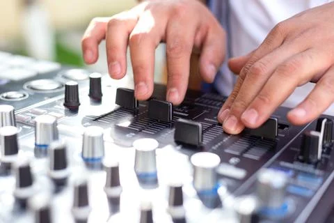 DJ Hands creating and regulating music on dj console mixer in concert party.. Stock Photos