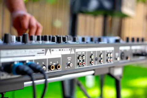 DJ Hands creating and regulating music on dj console mixer in concert party.. Stock Photos