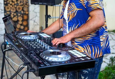 DJ Hands creating and regulating music on dj console mixer in concert party.. Stock Photos