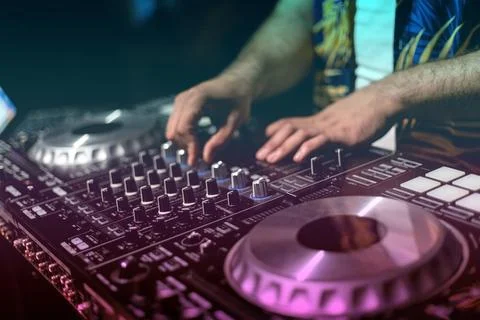 DJ Hands creating and regulating music on dj console mixer in concert party.. Stock Photos