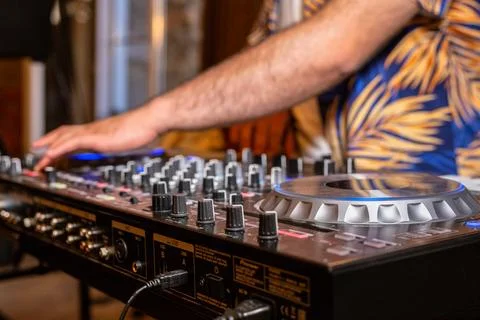 DJ Hands creating and regulating music on dj console mixer in concert party.. Stock Photos