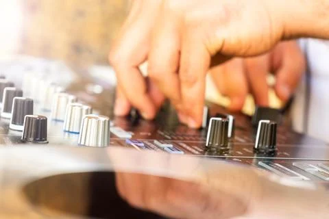 DJ Hands creating and regulating music on dj console mixer in concert party.. Stock Photos