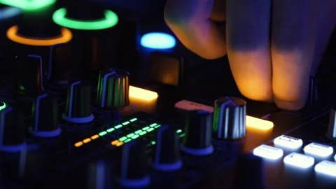 DJ hands mixing on console at night with colorful club lights. Stock Footage 317488913