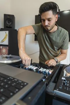 DJ having a good time while pressing buttons on the console to create music Stock Photos