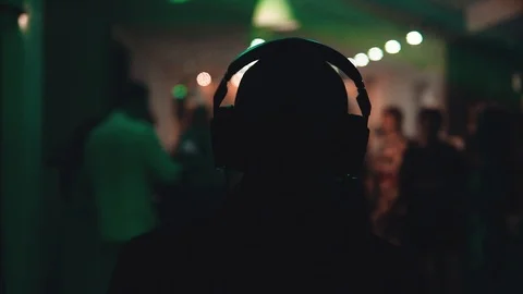 DJ with headphones playing its set before an active audience Видео 106095370
