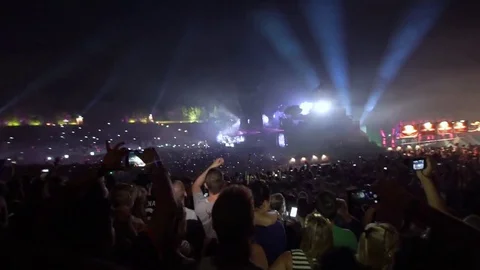 DJ on main stage lighting crowd of people dancing around on musical dance show Stock Footage 73752481