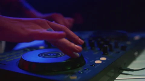 DJ mixes music using an audio mixer and turntables on stage. Knobs in hand Video stock 319762020