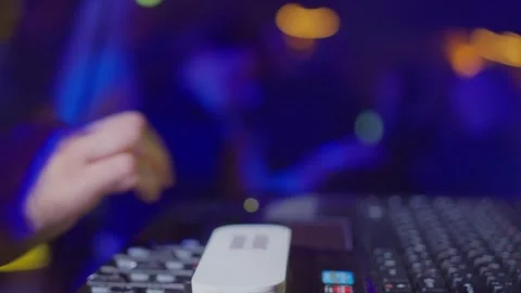 A DJ Mixing Console set within a vibrant nightclub environment full of exciting Video stock 303707941