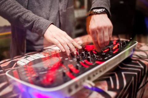 DJ mixing music on console at the night club Stock Photos
