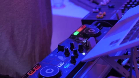 DJ mixing music on digital controller board in neon light Stockbeeldmateriaal 345115676
