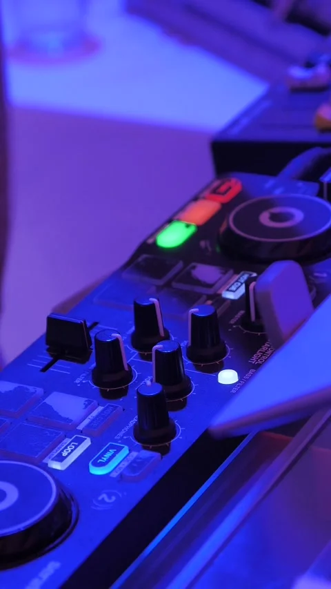 DJ mixing music on digital controller board in neon light Stockbeeldmateriaal 345115727