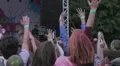 DJ performance on stage, crowd of fans enjoying music, jumping, waving hands HD Footage
