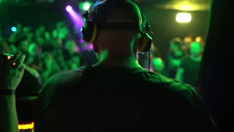 DJ performing techno inside a crowded club during a high energy nightlife party Stock Footage 331566027
