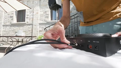 DJ plugging cables into DJ console, outdoor event setup, Italy 動画素材 338287102