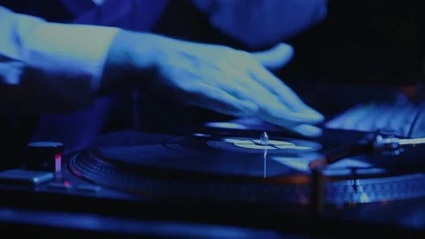 The DJ puts the record in the turntable and plays club music. Retro analog audio Stock Footage 147529957