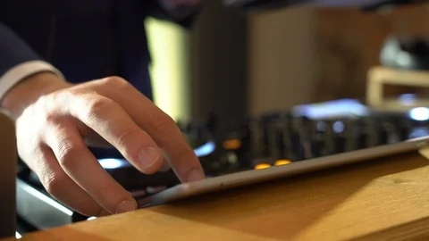 Dj selecting music on a computer tablet. DeeJay behind his setup choosing Stock Footage 128723966