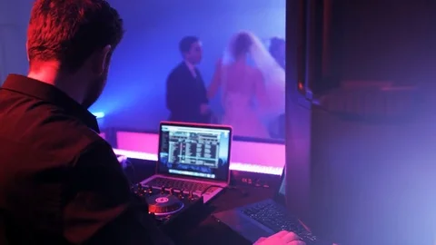 DJ Sitting in Front of the DJ Console Seen from the Side. Wedding party Stock Footage 71813110