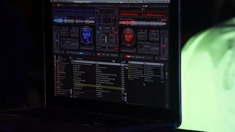 DJ software on a laptop at a party with flashing light show and dancers Stock Footage 123140100