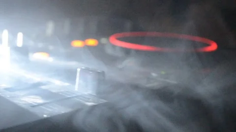 DJ Spinning, Mixing, and Scratching in a Night Club, strobe lights and fog Stock Footage