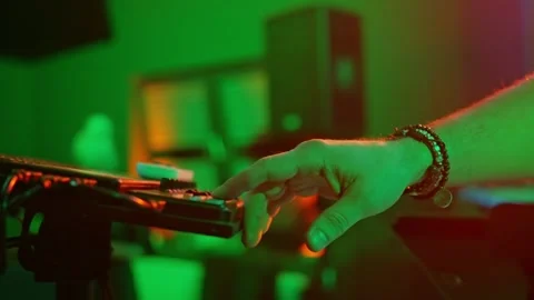 DJ spinning tracks to a keyboardist creating magic with green lights. Close up Stock Footage 267563448
