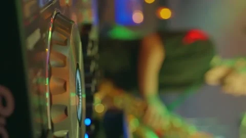 DJ spinning tracks on a mixer, controller and turntable in a lively club setting Stock Footage 268019983
