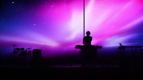 DJ is standing in front of big screen on the stage at dance club. Video stock 63139509