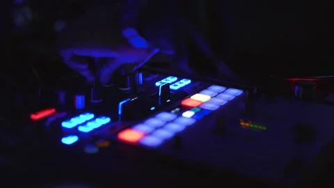 A Dj twisting knobs and adjusting the fader on a mixer in a nightclub 스톡 동영상 130709580