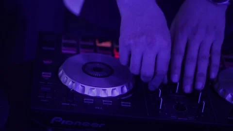Dj at work. Hands of DJ tweak various track controls on dj's deck Stockbeeldmateriaal 142883724