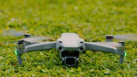 DJI Air 2S quadcopter, which floats in the air above the green grass, stops the Stock-Footage 346364584