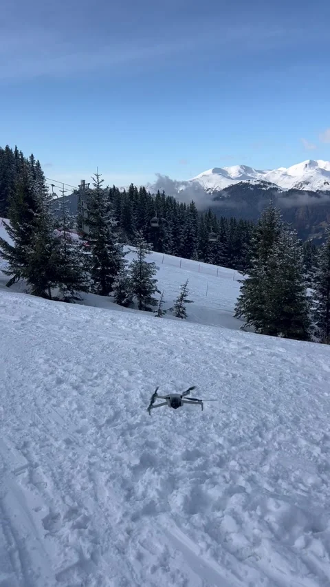 Dji Drone landing  between snowy mountains in a ski resort Stock Footage 334441470