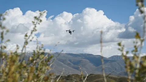 DJI Inspire-1 PRO drone rises into the air among the mountains Stock Footage 77260003