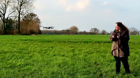 DJI Mavic 2 Pro drone from DJI is flown on a green meadow by a female pilot Stock Footage 151275623