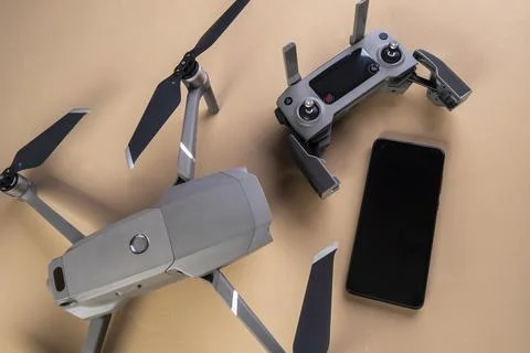 DJI mavic 2 pro drone, its controller and a smartphone on brown background Stock Photos