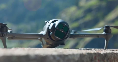 DJI Mavic 4 Pro drone positioned on a stone wall with mountains in the Stock Footage 334093953