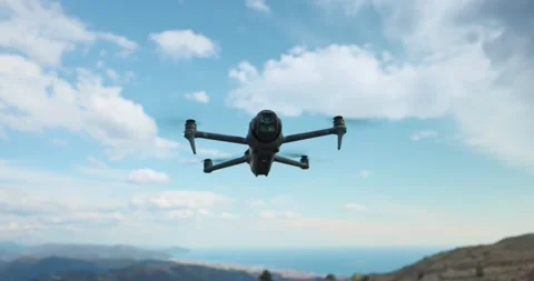 DJI Mavic 4 Pro drone hovering in mid air against cloudy blue sky in Stock Footage 341455471