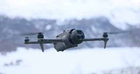 DJI Mavic drone hovering against winter snow mountain. Close-up Stock Footage 339106195
