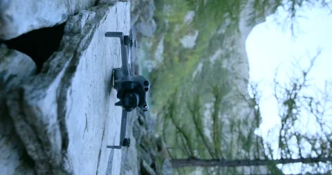 DJI Mini 4 Pro drone resting on a rock, preparing to record aerial footage Stock Footage 334358642