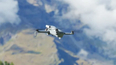DJI Mini drone flying in front of a mountain landscape Stockbeeldmateriaal 331028861