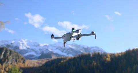 DJI Mini drone hovering with snowy mountains in background Stock Footage 341439488