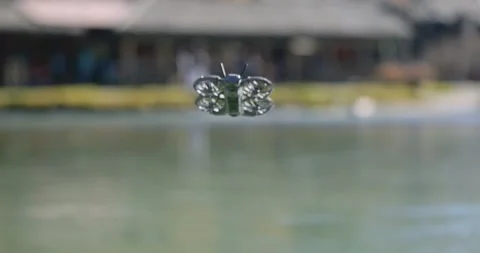 DJI Neo 2 drone flying low over lake water against blurred background. Copy Видео 336657520