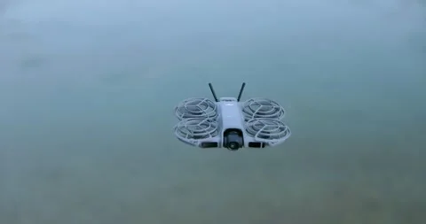 DJI Neo 2 drone hovering in mid-air against blurred background. Close up, copy Stock Footage 336657398