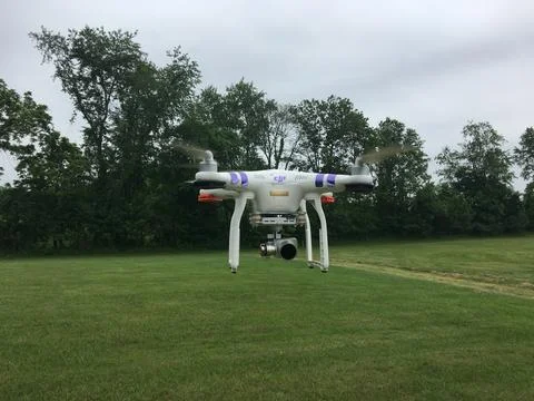 DJI Phantom 3 Camera Drone Hovering Over a Grassy Field Stock Photos