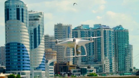 Dji Phantom 4 in the frame. Quadcopter on the background of houses. Drone flies Stock Footage 91995916