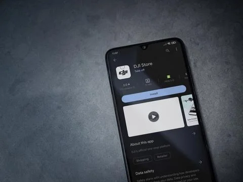 DJI Store app play store page on smartphone on a dark marble stone background Stock Photos