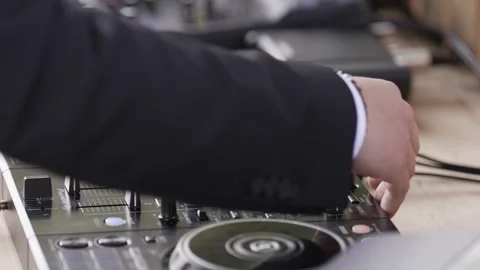 DJ's hand adjusting knobs and mixing tracks on a professional DJ console 库存影片 285415331