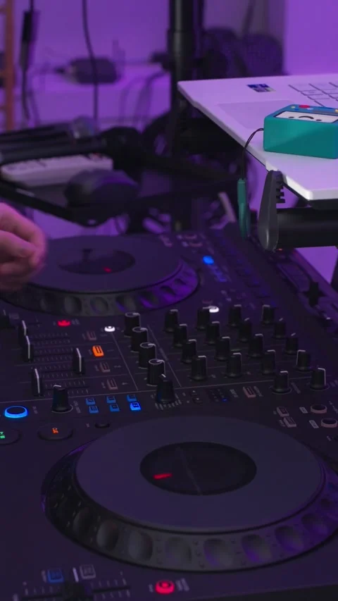 DJ's hand adjusting knobs on a professional audio mixer and controller. Stock Footage 312269030