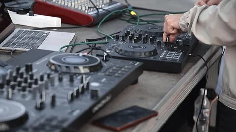 DJs hands adjusting knobs and controls on mixer during an outdoor Stock Footage 317038191