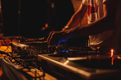 The DJ's hands turn the knobs on the remote control, the musician plays techn Stock Photos