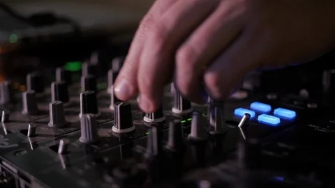 DJ's hands twist the knobs on the mixing audio console Stock Footage 111517953