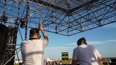 DJs perform in the open air, and clap their hands and play music for the crowd Video stock 127039872